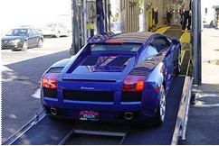 Photograph of a blue car being loaded onto a northAmerican moving van