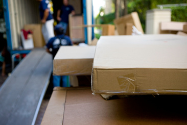 Photograph of a moving truck and boxes stacked outside the truck